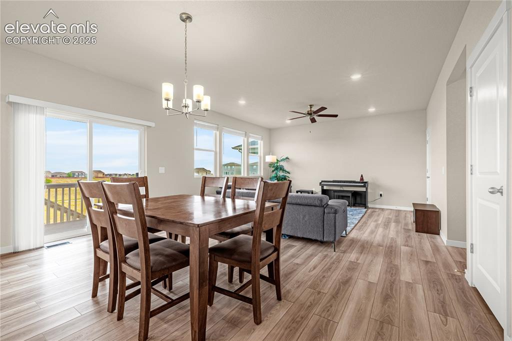 Image 5 of 30: Open-concept living space with wood-finish flooring, vaulted ceilings, rece