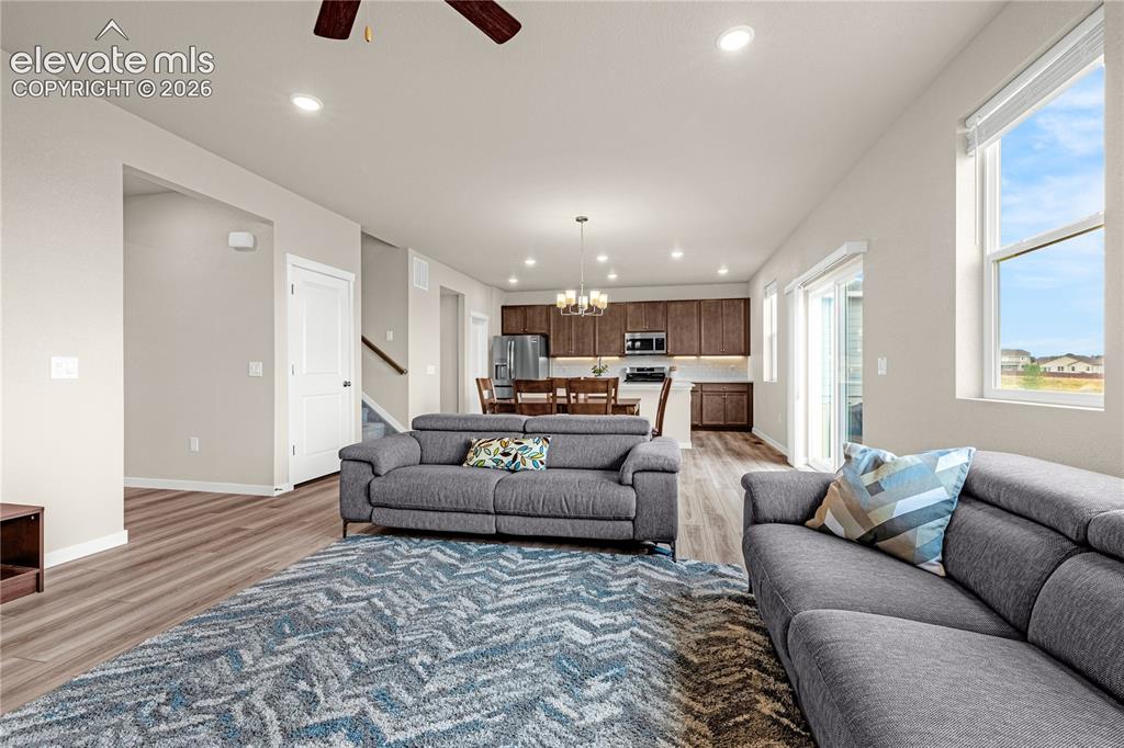 Image 7 of 30: Open-concept living space featuring wood-finish flooring, recessed lighting