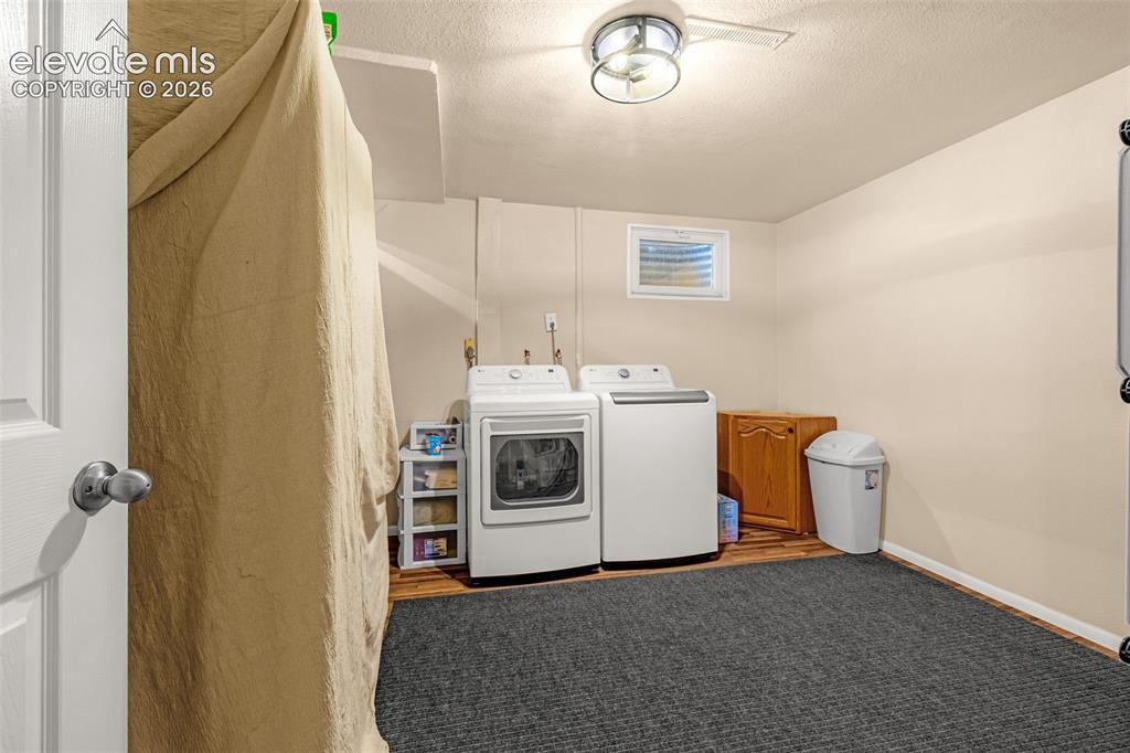 Image 18 of 27: Laundry area with laminate wood-finish flooring and a recessed window