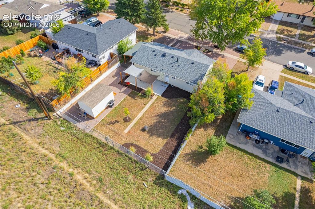 Image 23 of 27: Expansive fenced backyard with a detached shed, crushed asphalt driveway, a