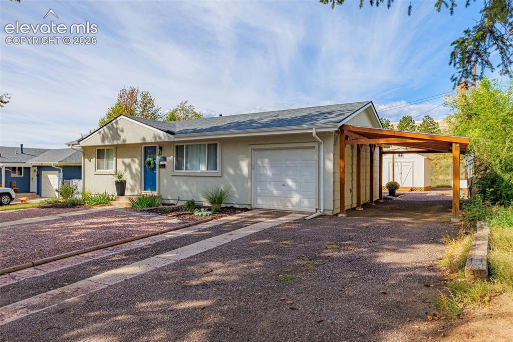 Image 24 of 27: Attached single-car garage with attached carport and a detached storage she