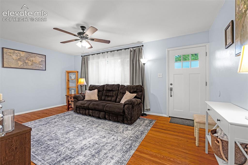 Image 5 of 27: Hardwood flooring throughout, a white paneled entry door with glass, and a