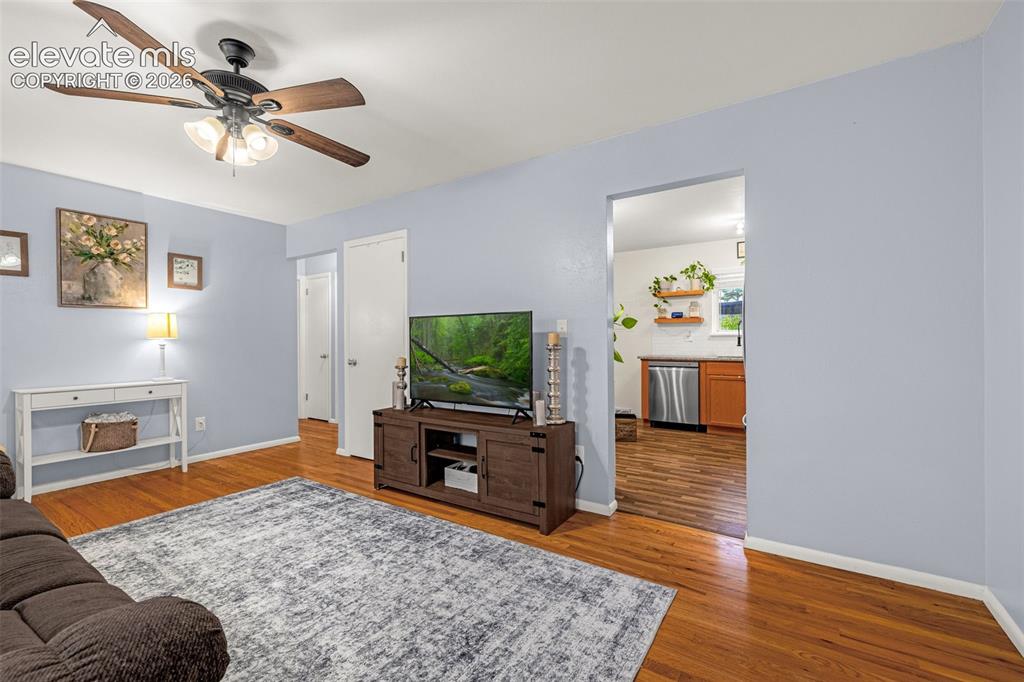 Image 6 of 27: Hardwood flooring, painted walls, ceiling fan with integrated lighting, and