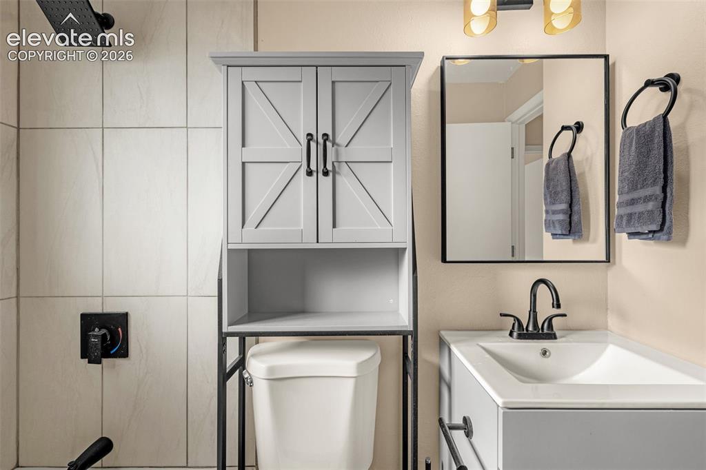 Image 9 of 27: Black square-framed mirror, contemporary black faucet, vessel sink, and an 