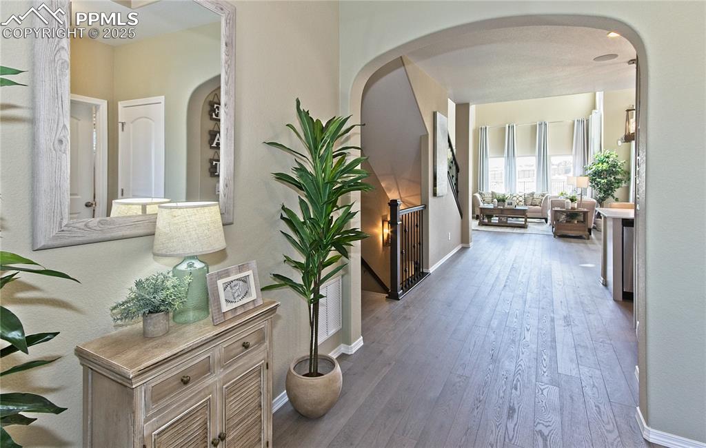 Image 2 of 25: Corridor with hardwood / wood-style floors and arched walkways