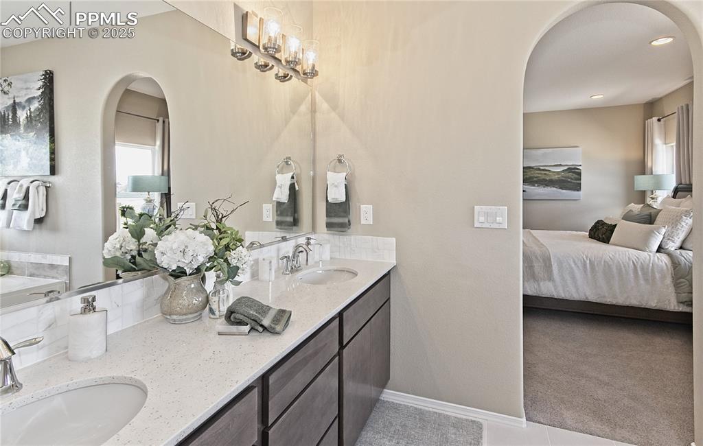 Image 25 of 25: Full bathroom featuring double vanity, connected bathroom, and tile pattern