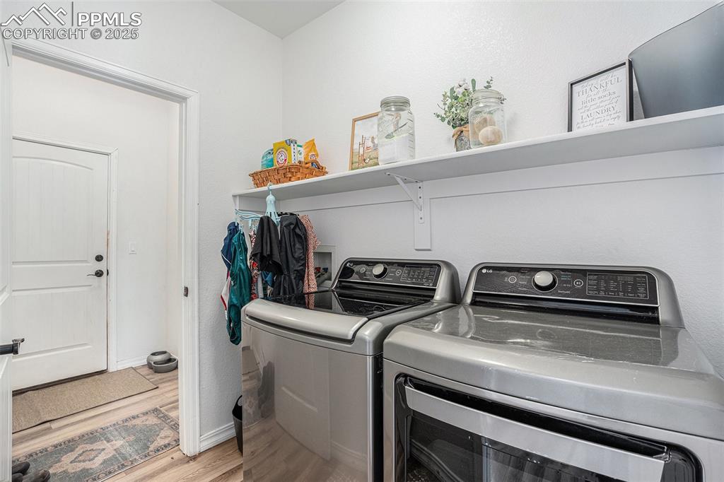 Image 17 of 24: Laundry area featuring light wood-style flooring and washing machine and dr