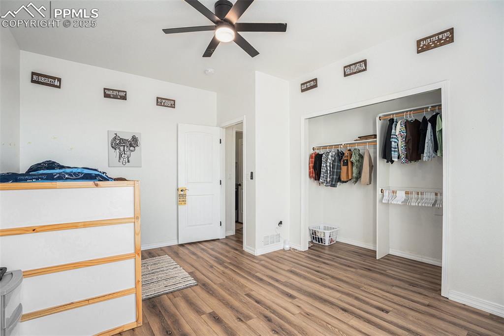 Image 19 of 24: Bedroom featuring wood finished floors, a closet, and a ceiling fan