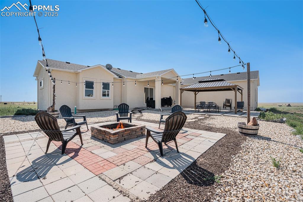 Image 21 of 24: View of patio / terrace with an outdoor fire pit and a gazebo