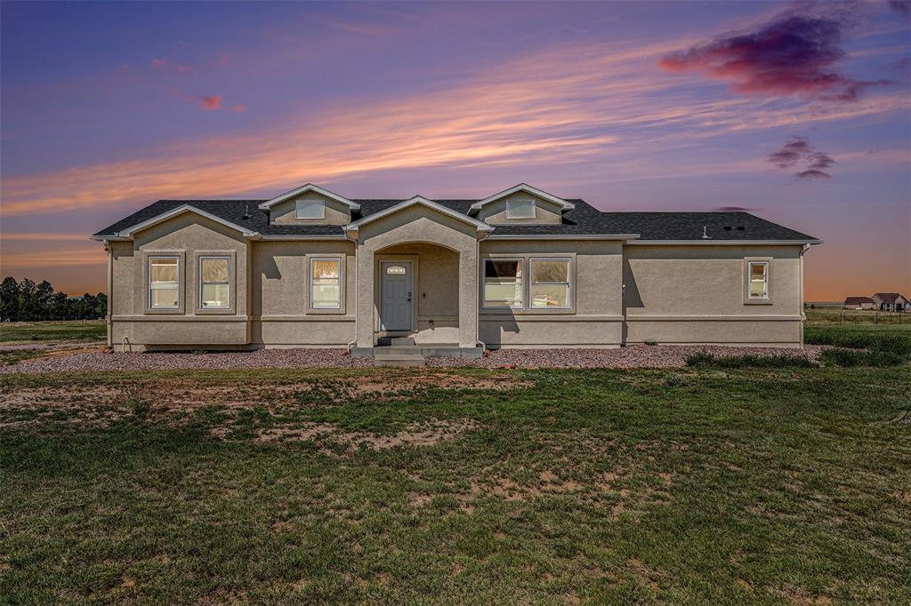 Image 25 of 25: View of front of property featuring stucco siding, a front lawn, and a shin