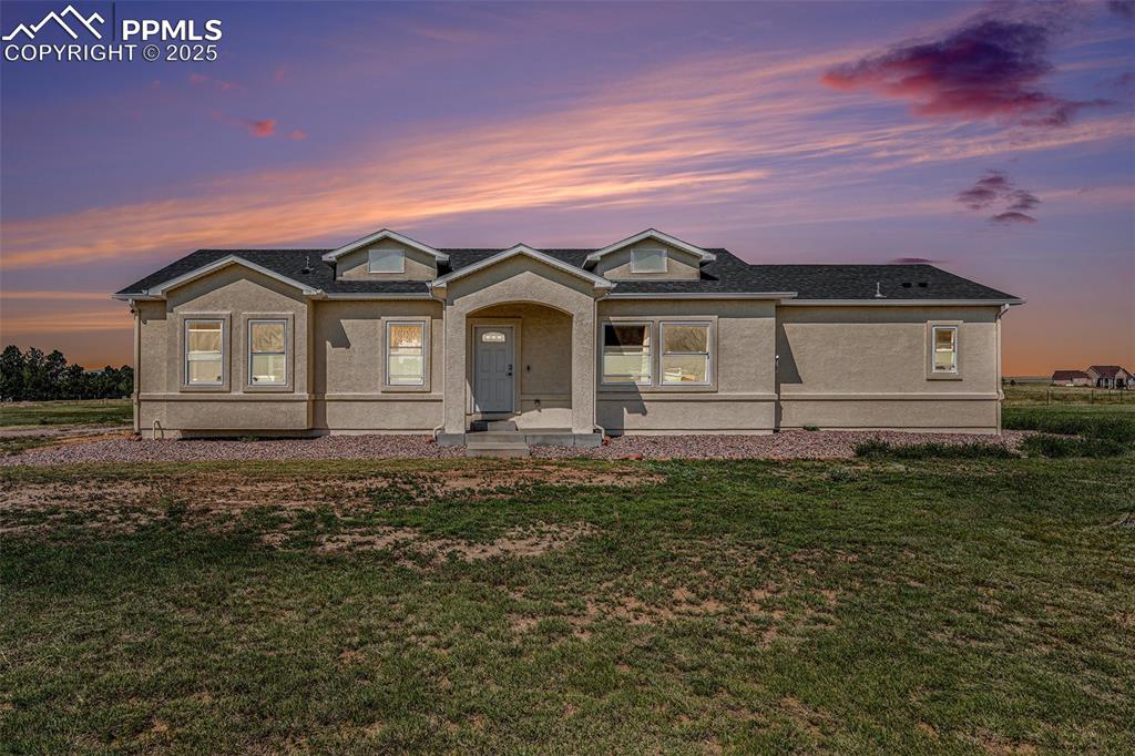 Image 3 of 24: View of front of property featuring stucco siding, a front lawn, and a shin