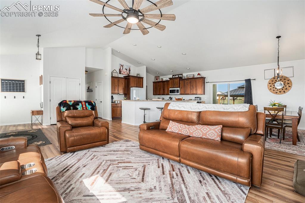 Image 5 of 24: Living area featuring a ceiling fan, light wood-style flooring, and high va