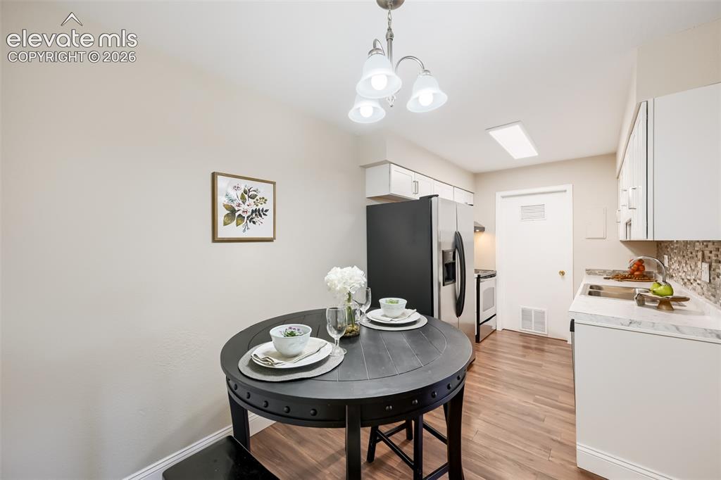 Image 6 of 10: Dining area with new light fixture, new flooring