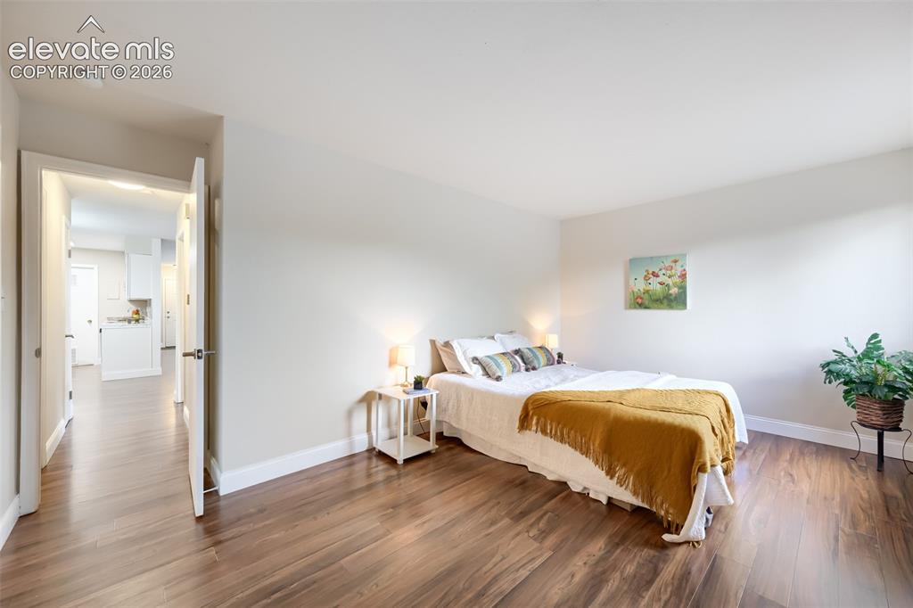 Image 8 of 10: Large primary bedroom with new floors, baseboard and paint