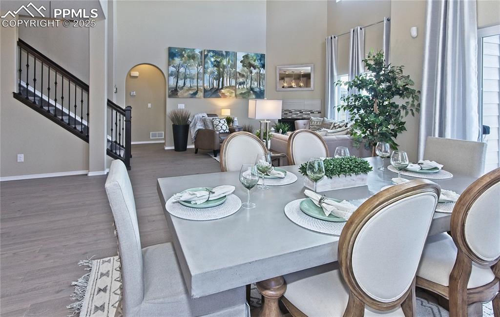 Image 12 of 30: Dining room featuring stairway, wood finished floors, arched walkways, and 