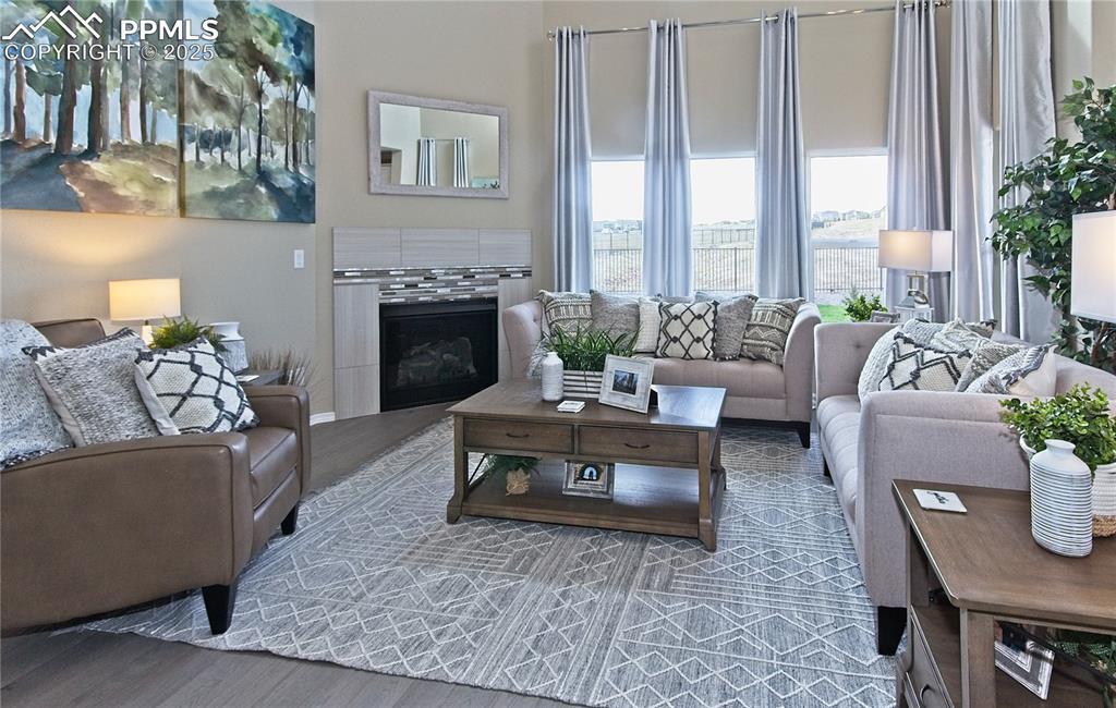 Image 14 of 30: Living room featuring wood finished floors and a tile fireplace