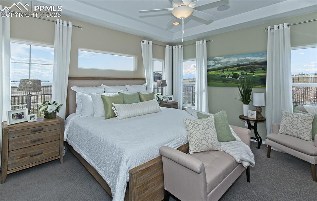 Image 15 of 30: Bedroom featuring a ceiling fan, carpet flooring, and a raised ceiling