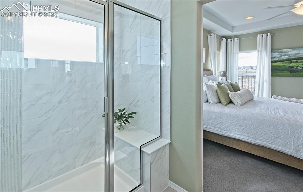 Image 18 of 30: Full bathroom with ensuite bath, a marble finish shower, and a ceiling fan