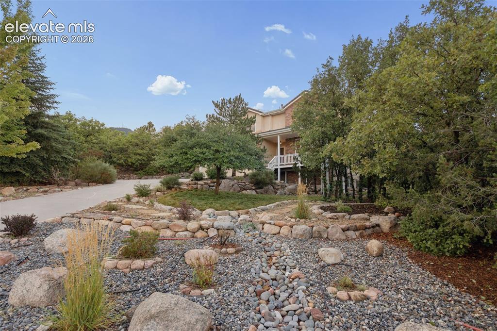 Image 39 of 47: Driveway and mature and meticulous landscaping 