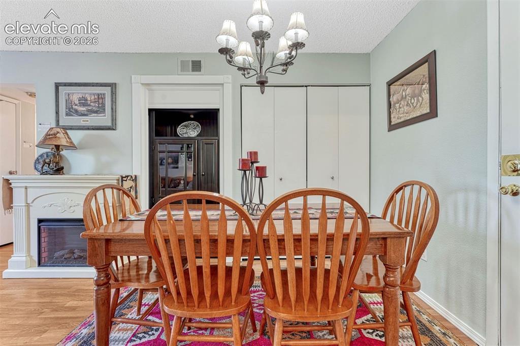 Image 10 of 35: Dining area featuring a decorative chandelier, light blue walls, wood-finis