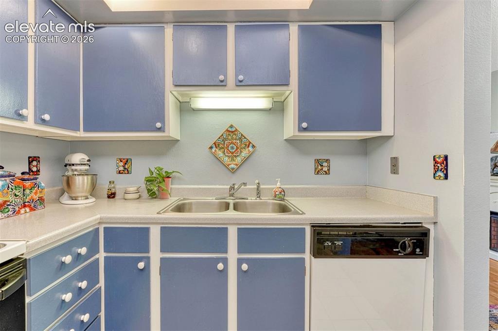 Image 12 of 35: Kitchen featuring blue cabinetry with white trim, white countertops, a doub