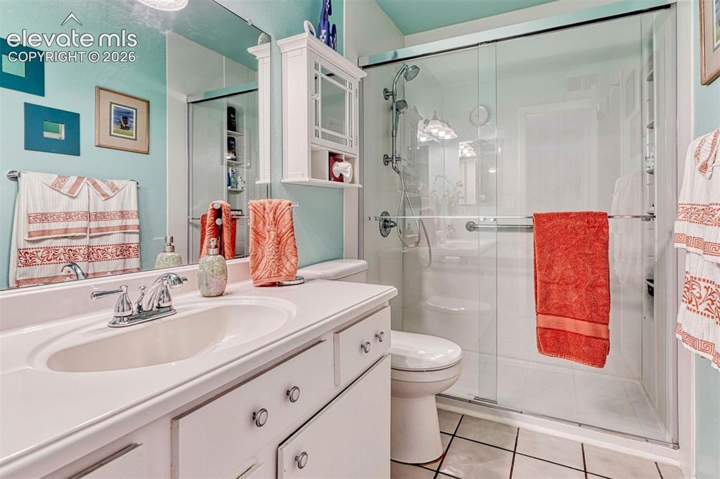 Image 15 of 35: Bathroom featuring a single vanity with a built-in sink, chrome faucet, and
