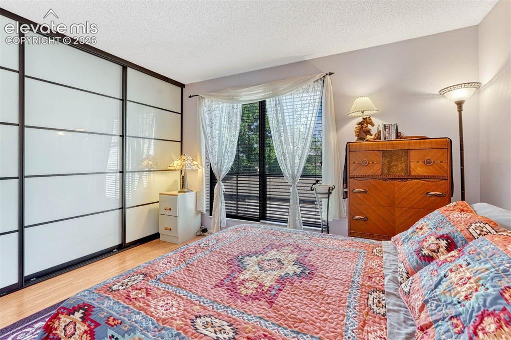 Image 17 of 35: Wall-to-wall wardrobe with sliding opaque glass doors and dark framing