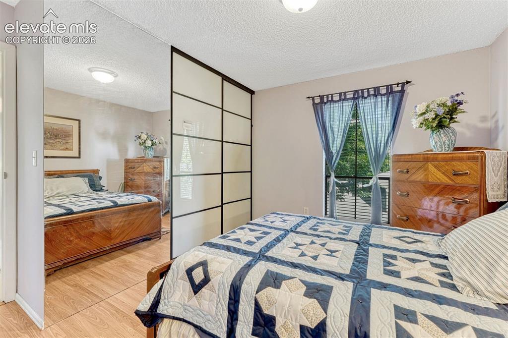 Image 19 of 35: Bedroom featuring wood-finish flooring, a window with horizontal blinds, an