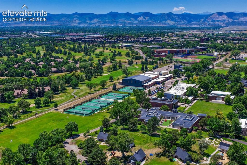 Image 29 of 35: Expansive aerial landscape featuring a golf course, multiple tennis courts,