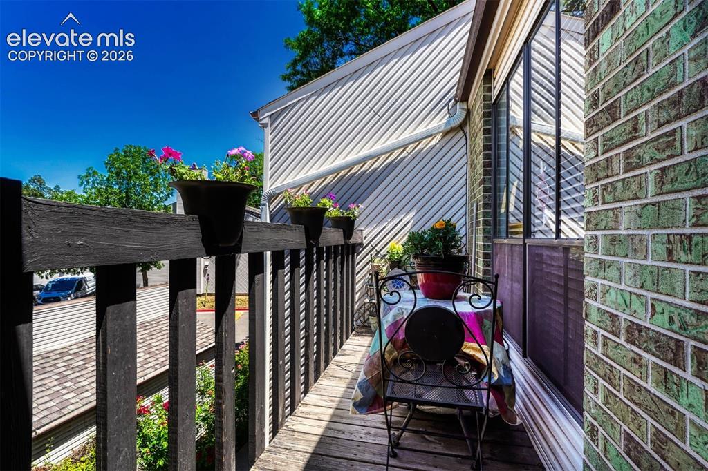 Image 5 of 35: Private balcony featuring wood-finish decking and dark wood railing