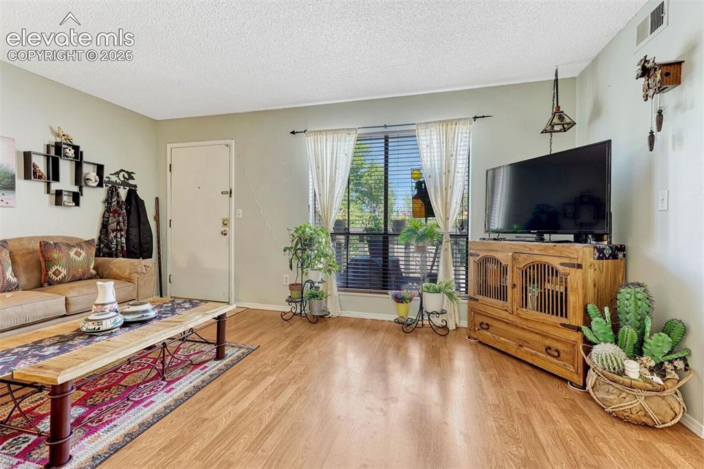 Image 8 of 35: Hardwood-finish flooring throughout, light-toned wall paint, textured ceili