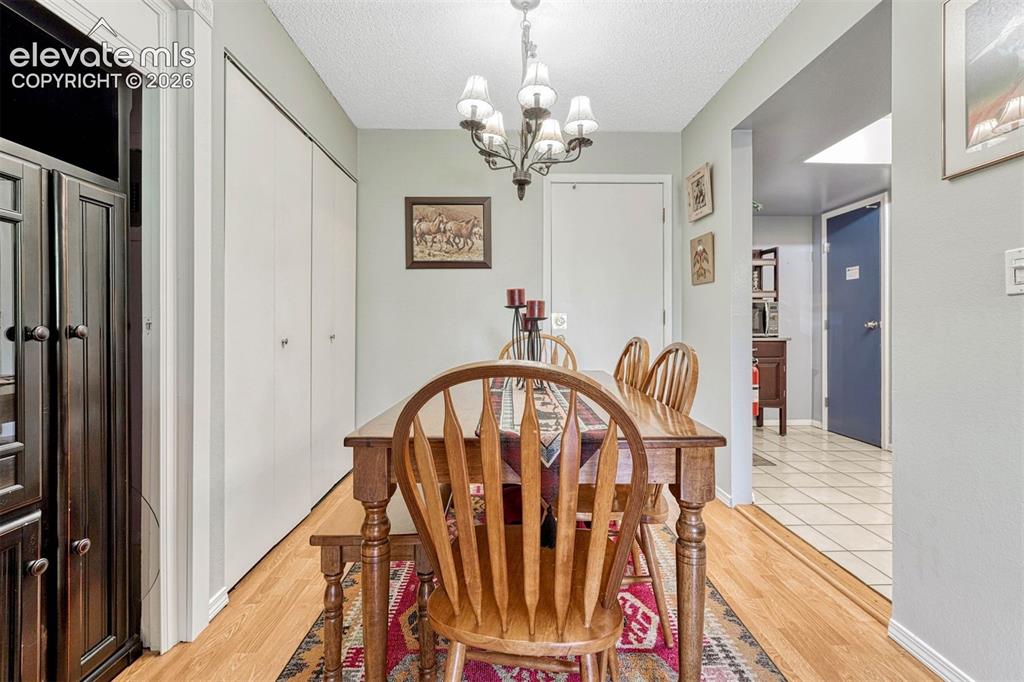 Image 9 of 35: Hardwood-style flooring throughout, complemented by a multi-bulb chandelier