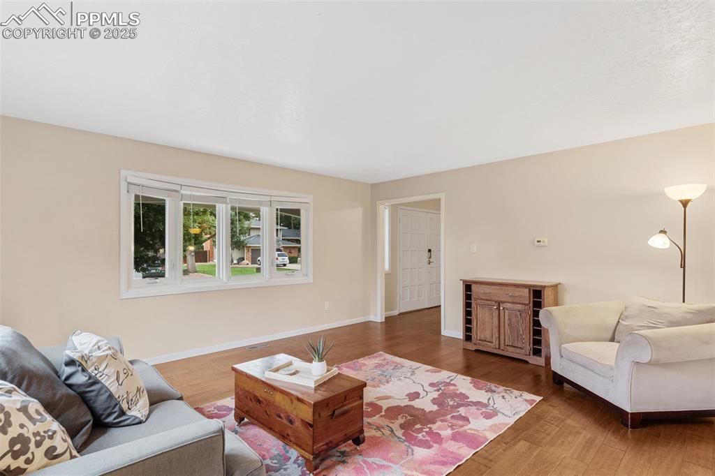 Image 10 of 45: Inviting living room at the front of the house with bay window and wood flo