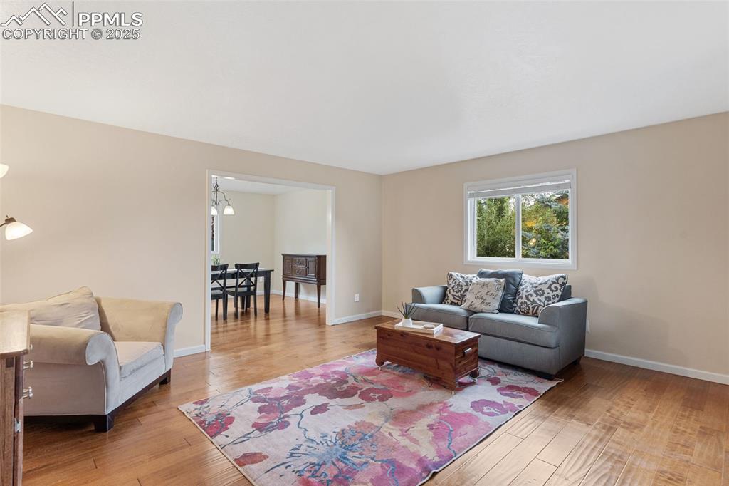 Image 12 of 45: Attractive living room with neutral colors and beautiful wood floor.