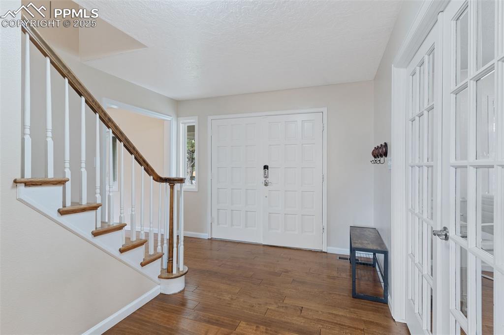 Image 5 of 45: Lovely entry with french doors leading to office (or 6th bedroom).