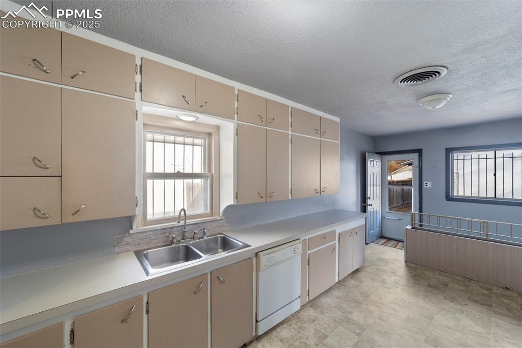 Image 15 of 41: Kitchen featuring light countertops, a textured ceiling, dishwasher, plenty