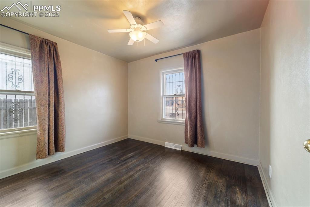 Image 16 of 41: Empty room featuring dark wood-type flooring and ceiling fan