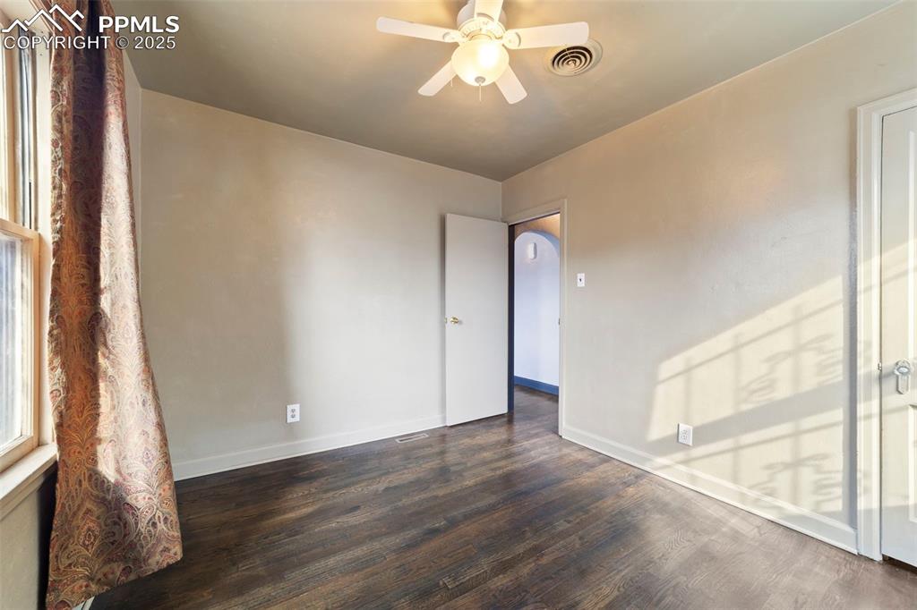 Image 17 of 41: Unfurnished room featuring dark wood-style flooring and a ceiling fan