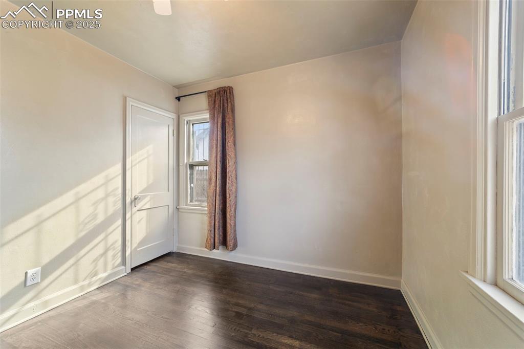 Image 18 of 41: Unfurnished room with dark wood-type flooring and baseboards