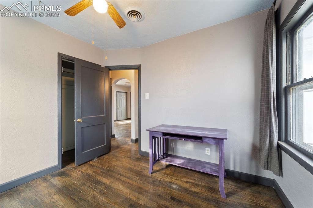 Image 21 of 41: Unfurnished bedroom with dark wood-style flooring, arched walkways, multipl