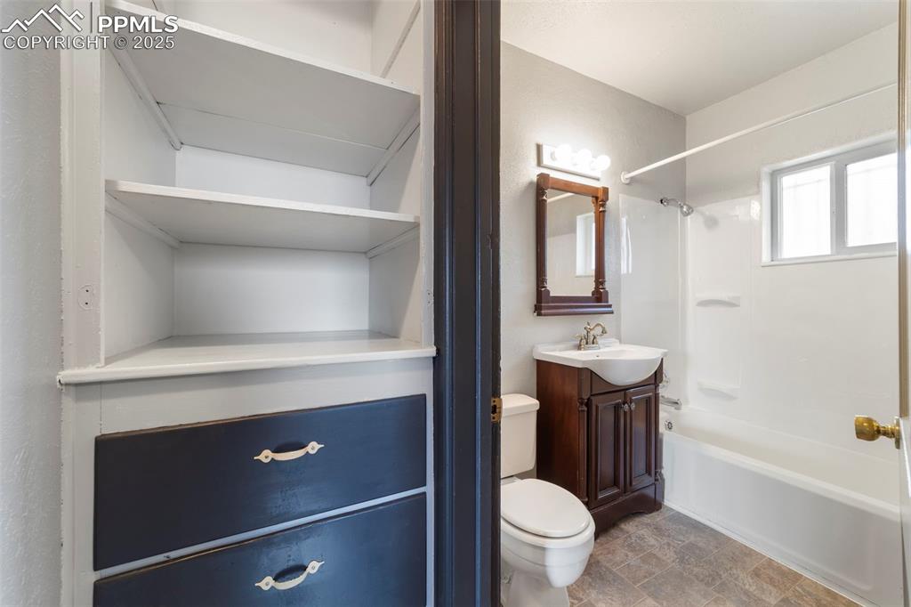 Image 24 of 41: Full bathroom with vanity, bathtub / shower combination, stone finish floor