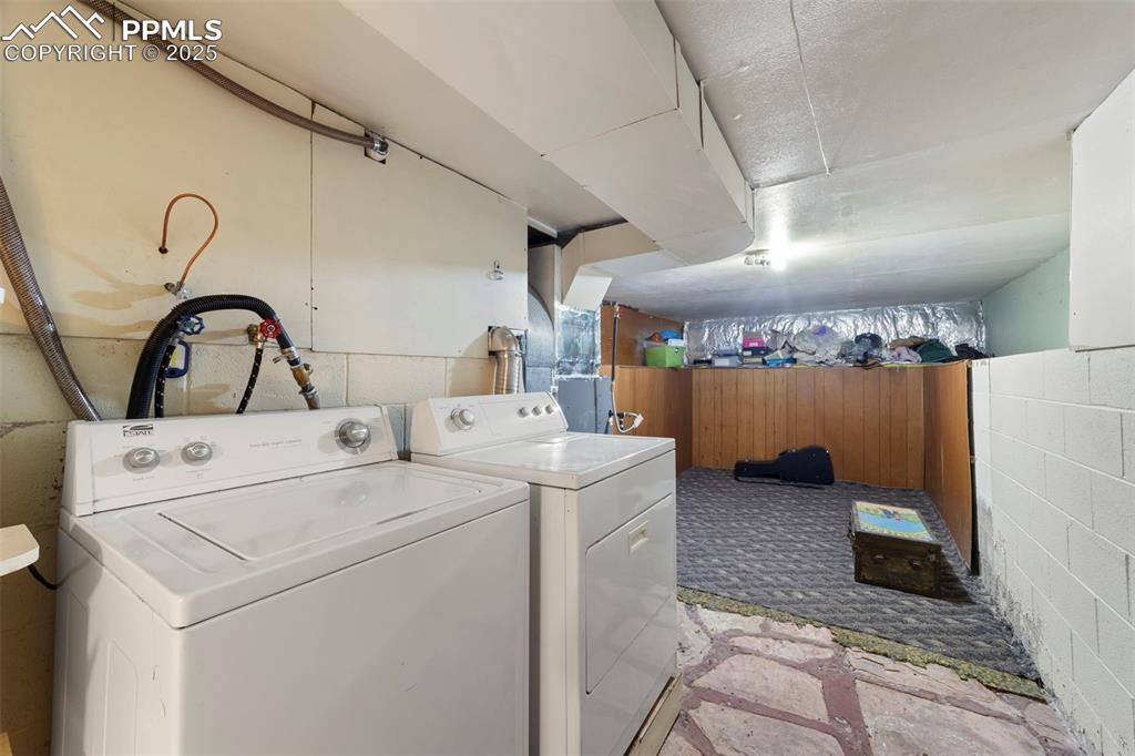 Image 28 of 41: Laundry area featuring washing machine and dryer and wooden walls