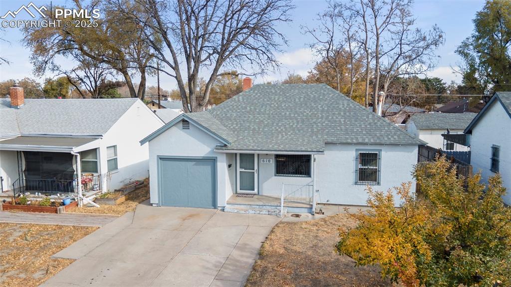 Image 3 of 41: View of front of house with roof with shingles, stucco siding, driveway, an