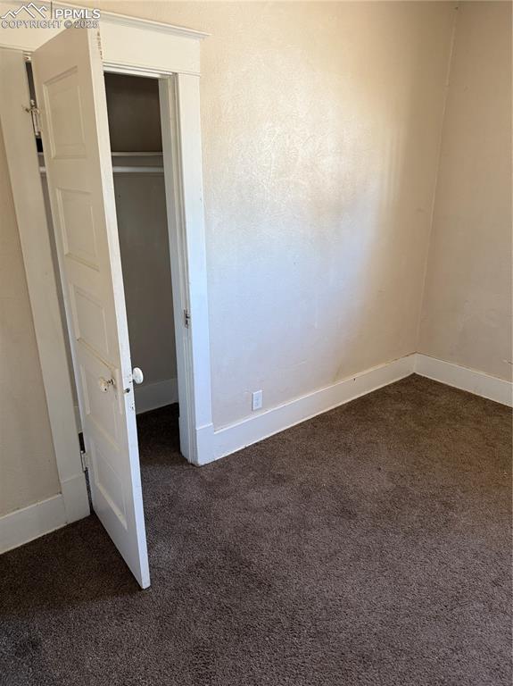 Image 6 of 11: Unfurnished bedroom featuring dark carpet and a closet