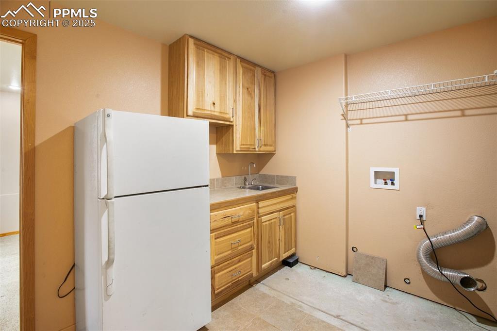 Image 33 of 50: Sink and refrigerator in laudnry room