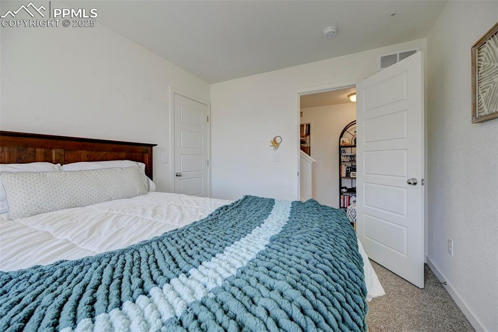 Image 20 of 32: Carpeted bedroom with baseboards and visible vents