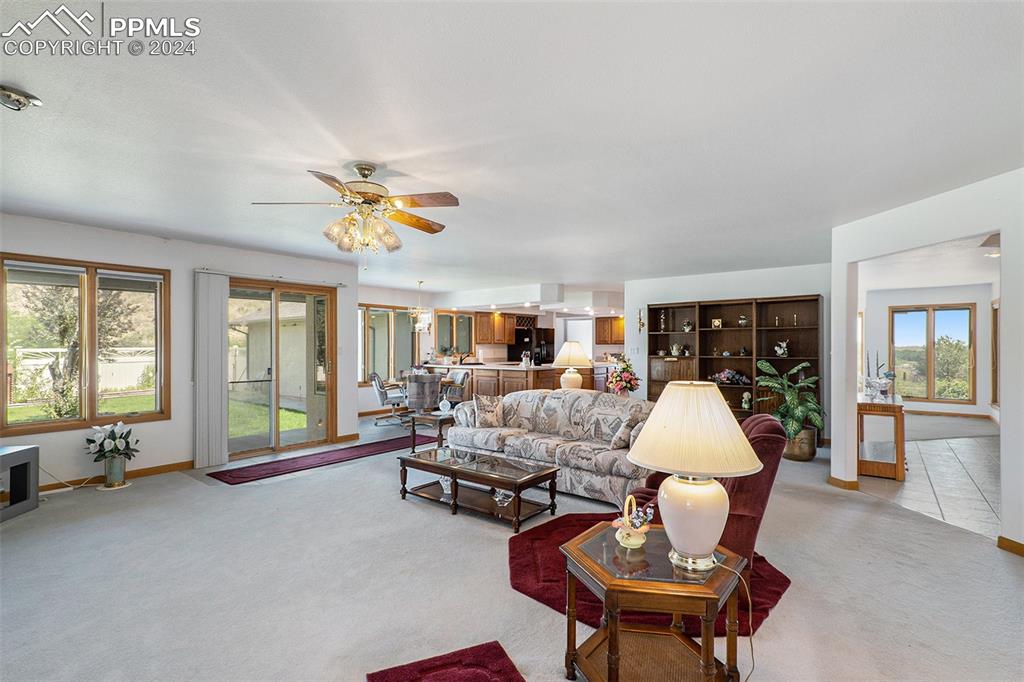 Image 10 of 50: Carpeted living room featuring ceiling fan