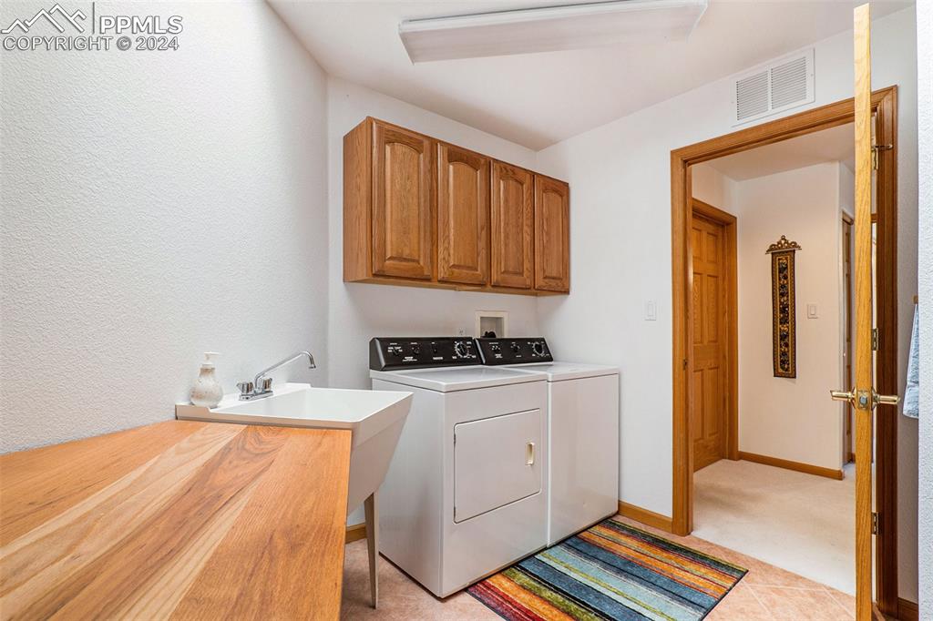 Image 20 of 50: Laundry room with washer hookup, cabinets, washer and dryer, and light tile