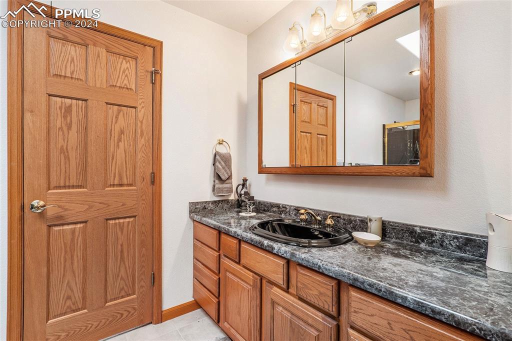 Image 21 of 50: Jack and Jill Full Bathroom with tile floors and vanity