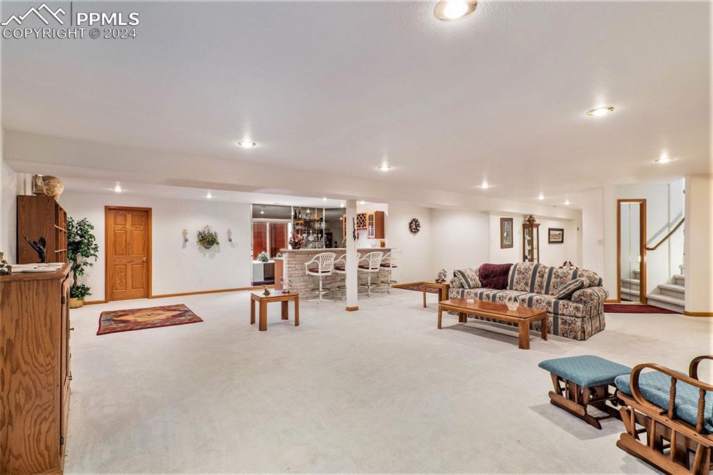 Image 31 of 50: Carpeted great room featuring wet bar area